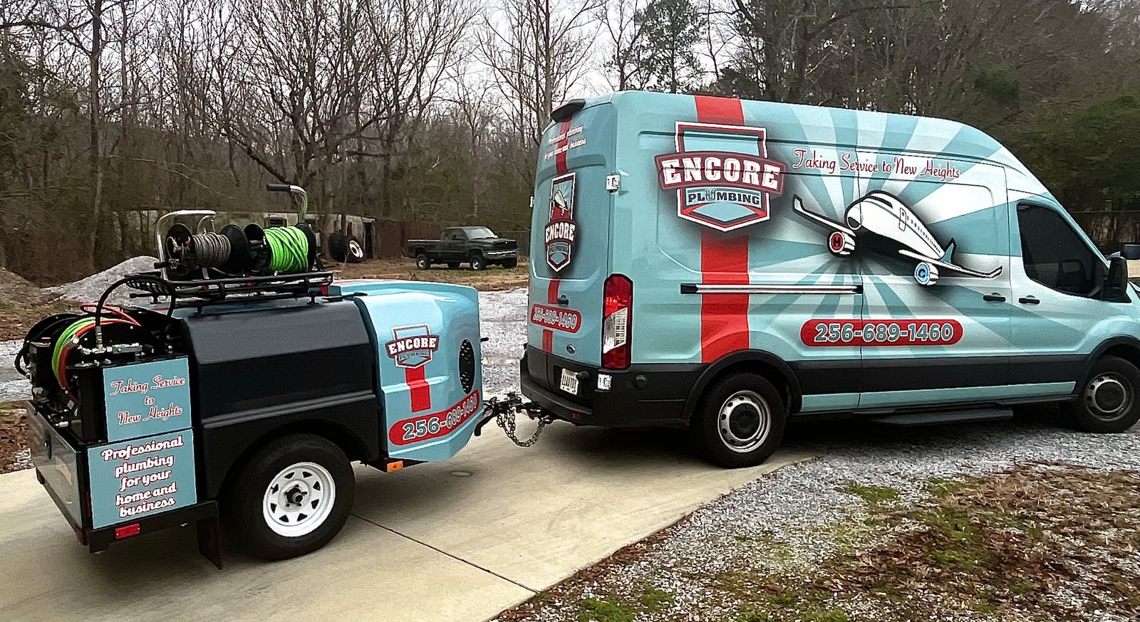 Encore Plumbing hydro jetting trailer with hose reels hitched to the wrapped service van