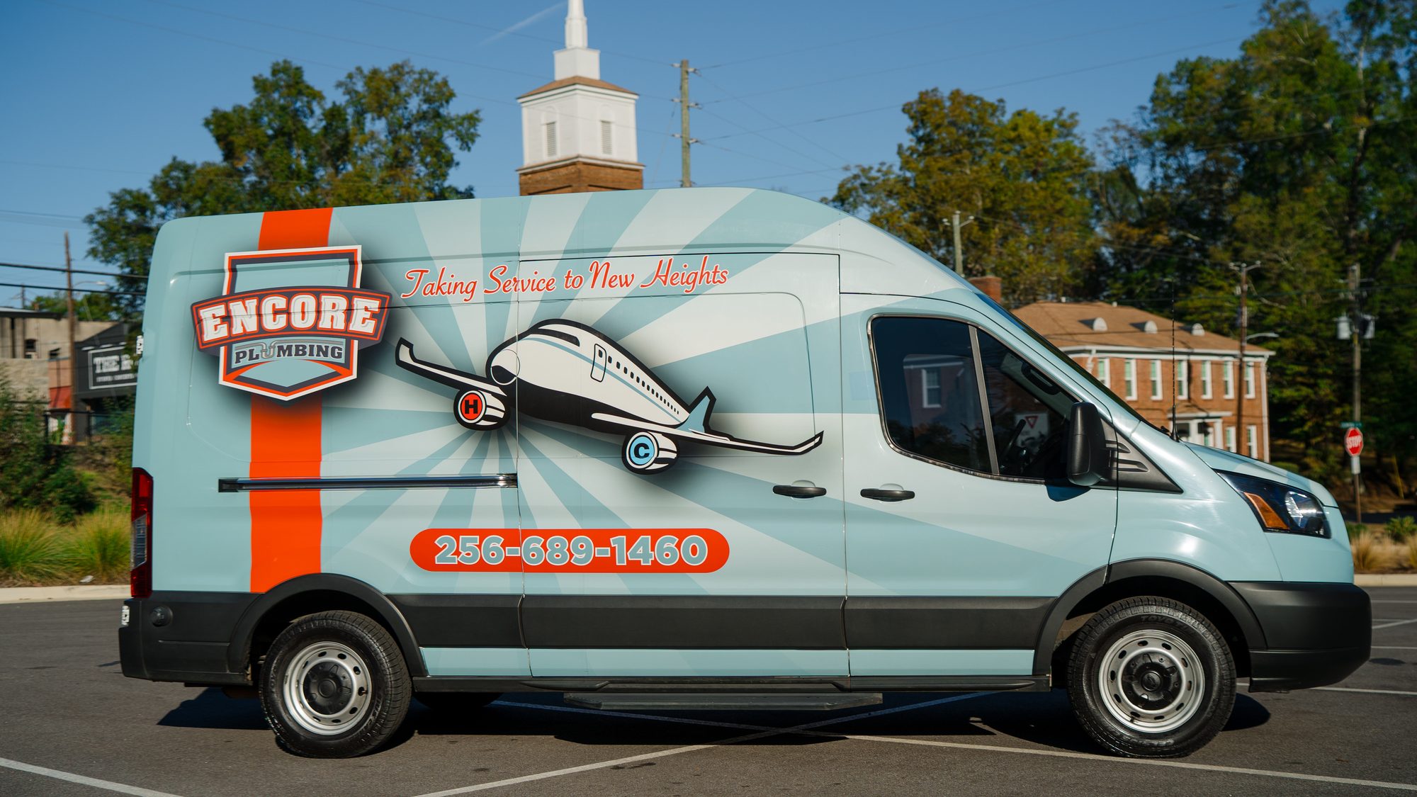 Encore Plumbing service van in Jacksonville, Alabama with the retro airplane wrap and the phone number 256-689-1460